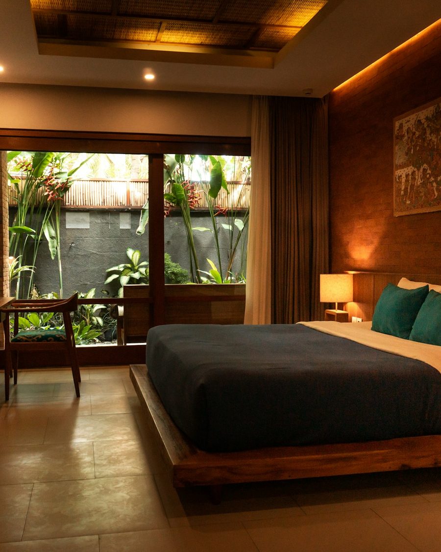 A hotel bedroom with a robe hanging beside the window